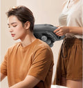 ReliefPro massager being used on a person's neck and shoulders